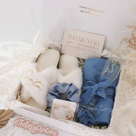 Step into a world of luxury with our Dusty Blue Fluffy Slippers Bridesmaid Gift Box. Designed for the modern bride who wants to spoil her bridal party, this exquisite gift box includes a sumptuous satin robe, a matching hair scrunchie, a personalized mimosa champagne glass, and a pair of white personalized fluffy slippers together with a minimal knot bracelet. Indulge your bridesmaids in pure comfort and style as they prepare for your special day. These handmade slippers are not only cozy and so Gift For Bridesmaids On Wedding Day, Something Blue Gift Ideas, Bridesmaid Gifts Day Of Wedding, Day Of Bridesmaid Gifts, Bridesmaid Proposal Blue, Slippers Bridesmaid, Mimosa Champagne, Bachelorette Signs, Diy Bridesmaid Gifts