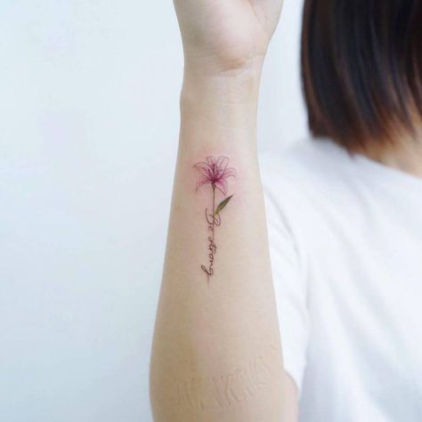 Be Strong Tattoos For Women, Wrist Lily Tattoo, Lily Name Tattoo Design, Lily Wrist Tattoos For Women, Colored Minimalist Tattoo For Women, Water Lily Name Tattoo, Lily Tattoo With Words, Small Tiger Lily Tattoo, Lily Tattoo On Wrist