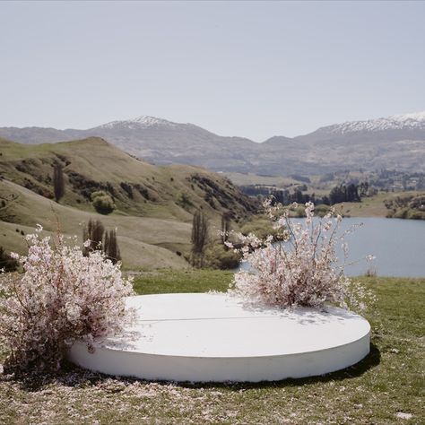 White round platform with cherry blossom arrangements. Lake views from NZ high Country in Queenstown. Spring wedding with LGBTQ+ inclusive wedding vendors. Ceremony Platform, Wedding Platform, Enjoy Your Special Day, Ceremony Florals, Wedding Alters, Ceremony Chairs, Floral Installations, Queenstown New Zealand, Wedding Info