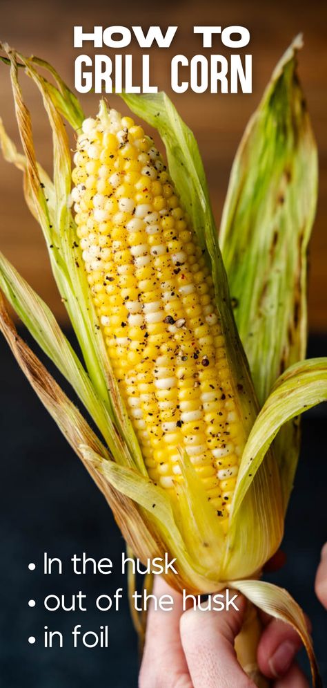 A hand holding an ear of corn with the husk partially removed. Corn On The Grill In Husk, Bbq Corn On The Cob In Husk, Grill Corn On The Cob In Husk, How To Grill Corn On The Cob, Grilled Corn On The Cob In Husk, Grill Corn In Husk, Bbq Corn On The Cob, How To Grill Corn, Grill Corn On The Cob