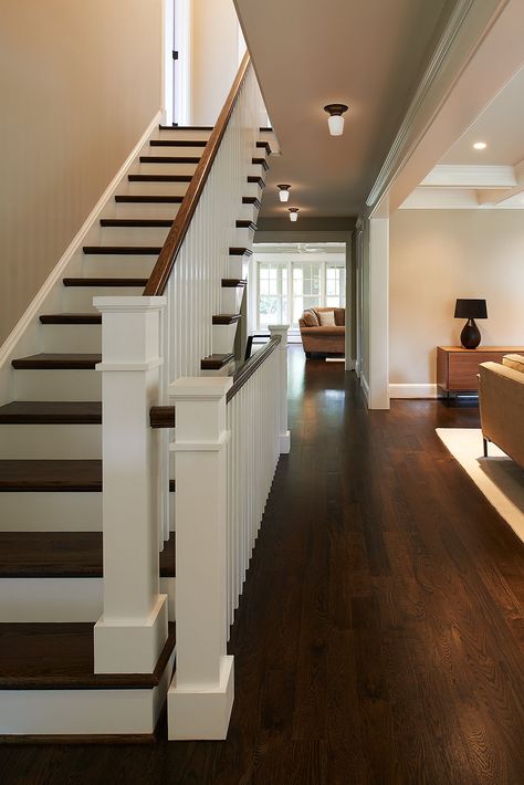 The dark hardwood floors contrast the crisp white newel posts and ballusters on this staircase. Stain Staircase, Stained Staircase, Brown Stairs, Dark Hardwood Floors, Townhouse Interior, Hardwood Floors Dark, Dark Hardwood, Newel Posts, Walnut Stain