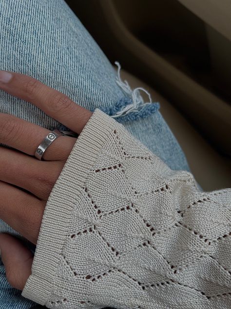 A picture of a hand with a crochet patterned long sleeve sweater and a silver Cartier love ring on. Beautiful tan skin and denim jeans Silver Love Ring Cartier, Cartier Love Ring Aesthetic, Cartier Love Ring Silver, Cartier Ring Aesthetic, Silver Cartier Ring, Cartier Aesthetic, Chic Style Women, Cartier Love Ring, Pretty Accessories