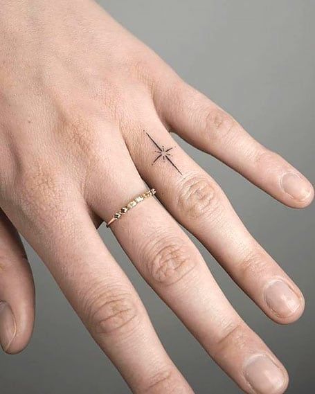 50 Dreamy Star Tattoos and Their Meanings (2022) - The Trend Spotter North Star Tattoo Finger, Star Ring Tattoo, Star On Finger Tattoo, North Star Finger Tattoo, Delicate Star Tattoo, North Star Tattoo Meaning, Sparkle Finger Tattoo, 2022 Tattoo Trends, Hand Sparkle Tattoo