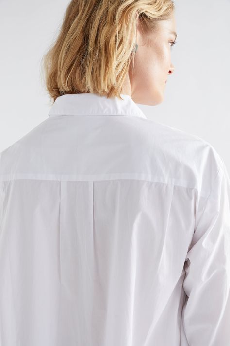 Product Details The Flikrin Shirt is one of this season's key styles combining directional style and practicality with ease. This organic cotton shirt features an extreme high-low hem where the back length flows to the ankle and the front length finishes at the hip. A cleverly-integrated panel and gusset at the side as well as a back yoke with a box pleat allow for freedom of movement. The slim sleeves finish with two buttons at the cuff and with a set in sleeve is easily layered under a sweater Blouse Reference, Shirt Yoke, Yoke Shirt, Woman Back, Statement Shirt, Box Pleats, Button Shirt, High Low Hem, Classic Shirt