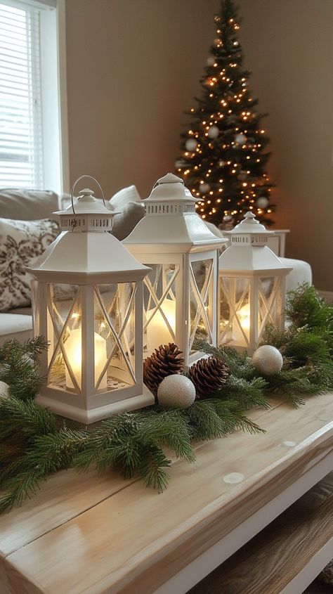 Festive coffee table centerpiece with white lanterns, pine cones, and greenery in a cozy winter living room setting. Christmas Coffee Table Centerpieces, Cozy Christmas Bedroom Aesthetic, Living Room For Christmas, Christmas Living Room Ideas, Classic Christmas Decor, Future Christmas, Living Room Ideas Cozy, Room Ideas Cozy, Cozy Lighting