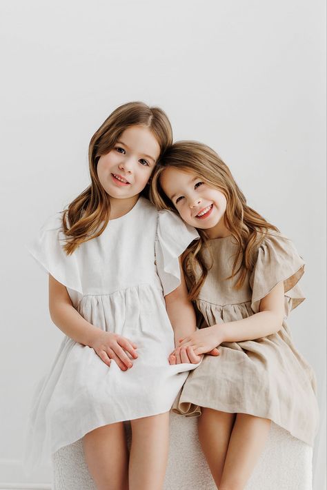 Little girls, sisters sitting for portrait Sibling Posing Photography, Poses For Two Sisters, Sibling Photography Poses Two, 2 Sisters Photography Sibling Poses, 3 Sibling Poses Photography, Cute Sibling Poses, Family Of 4 Portraits, Two Kids Photoshoot, Studio Sibling Photoshoot