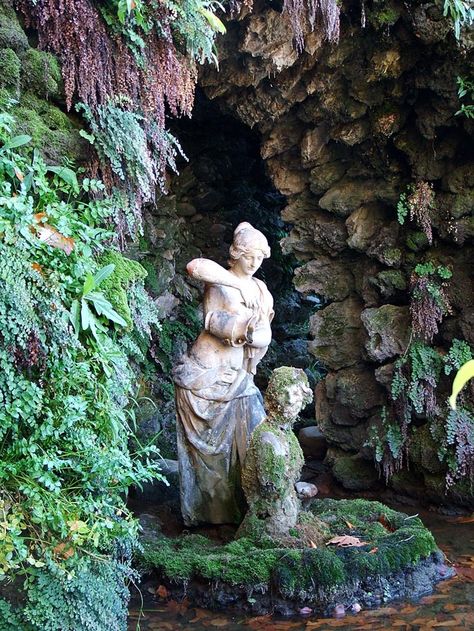 Garden grotto. Designed to resemble caves. Usually artificial structures decorated with rocks, shells, statues, plants, and fountains Gardens With Statues, Rock Statues Garden Sculptures, Forgotten Statues In Ponds, English Grotto Garden, Grotto Aesthetic, Grotto Design Ideas, Italian Grotto, Grotto Garden, Garden Grotto