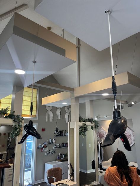 The hanging blow dryers look beautiful in this spacious salon. Hanging Hair Dryer, Blow Dryer Hanging From Ceiling, Black Ceiling Hair Salon, Hanging Mirror From Ceiling Salon, Blo Blow Dry Bar, Salon Dryers, Store Front, Blow Dryer, Track Lighting