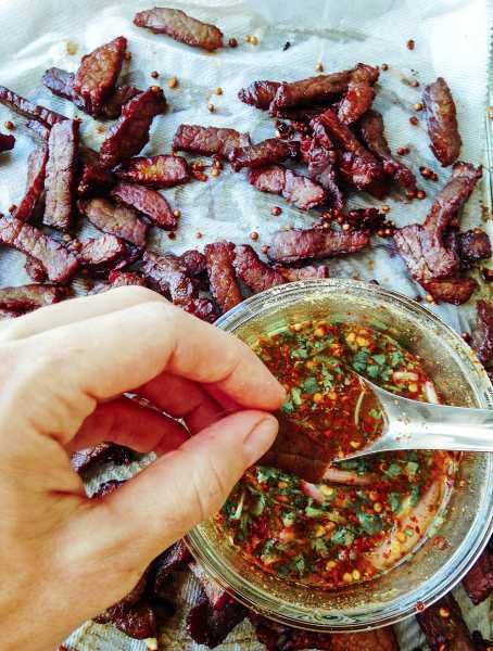 Homemade Thai Beef Jerky-Thai-Foodie: LOVE how Thai beef jerky is chewy and crispy and pairs perfectly with an easy Thai chili dipping sauce full of flavors like lime, shallots, cilantro, roasted rice powder and spicy Thai chili flakes! | thai-foodie.com Thai Beef Jerky Recipe, Thai Beef Jerky, Jerkey Recipes, Chili Dipping Sauce, Homemade Beef Jerky, Pork Jerky, Spicy Dipping Sauce, Dehydrated Foods, Thai Beef