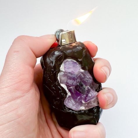 Someone holding a black handsculpted polymer clay lighter holder in their hand. It looks like a black geode with cracks in it. There are holes that show inside the fake geode- there are purple amethyst crystal shards. Clay Lighter Holder, Polymer Clay Geode, Clay Lighter, Fairy Frog, Lighter Holder, Clay Sculptures, Polymer Clay Sculptures, Amethyst Crystals, Sculpture Clay