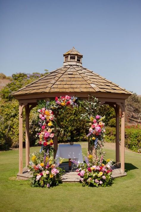 Vibrant floral arch gazebo wedding ceremony backdrop. Get inspired by this colorful Santa Barbara wedding at Glen Annie Golf Club. Captured by fine art editorial wedding photographer Morgan V Photo. Discover outdoor wedding ceremony inspo, garden wedding ideas, summer wedding color schemes and vibrant floral design ideas on the blog. Book Morgan V for your Santa Barbara California wedding at morganvphotography.com! Wedding Flowers On Gazebo, Gazebo Wedding Altar, Flower Gazebo Wedding, Gazebo Floral Arrangements, Gazebo Wedding Ceremony Decorations, Round Arch Flowers, Gazebo Decorating Ideas Wedding, Wedding Gazebo Decorations Outdoor, Summer Wedding Color Schemes