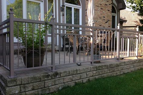 Custom iron railings on a raised patio. Designed and installed by First Fence Company in Hillside, IL. Raised Patio Balustrade, Raised Patio With Railings, Fence Around Concrete Patio, Concrete Patio Railing Ideas, Concrete Patio With Railing, Concrete Patio Railing, Iron Fences And Gates, Pool Fencing Landscaping, Poured Concrete Patio