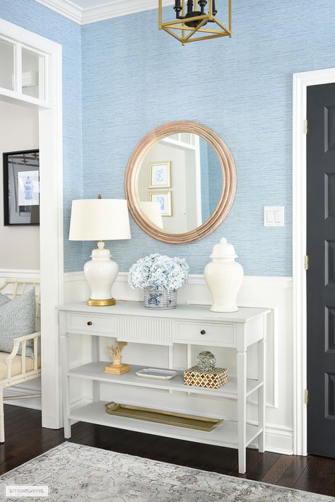 Entryway console table styled for spring with light blue and white accessories. Light Blue Home Aesthetic, Light Blue Entryway, Grand Millennial Entry Table, White Console Table Entryway, Console Table Decorating Entryway, White Coastal Console Table, White Console Table Entryway With Drawers, White Wntry Table, Coastal Entryway Ideas