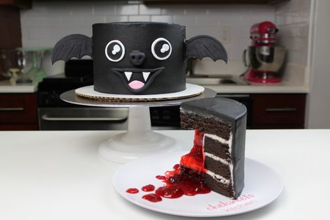 This vampire bat cake is perfect for Halloween! It's a little bit spooky with it's strawberry jam "blood" center, but also adorable with its smiling face and wings!! The full recipe for this black cocoa bat cake is up on chelsweets.com Creepy Cakes, Spooky Halloween Cakes, Bat Cake, Spooky Cake, Lemon And Coconut Cake, Huge Cake, Halloween Cake Decorating, Inside Cake, Rock Cake