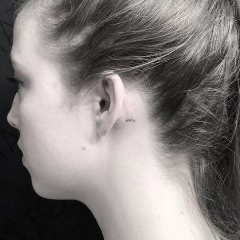 Tiny “m” letter tattoo behind the left ear. Letter Tattoos Behind The Ear, Behind The Ear Tattoo Ideas Letter, Tiny M Tattoo, Initals Tattoo Behind Ear, R Tattoo Behind Ear, A Tattoo Letter Behind Ear, Small M Tattoo Letter, Letter M Tattoo Ideas, Letter M Tattoos