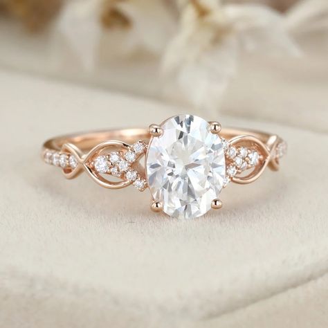 This stunning 1.5ct oval-shaped Moissanite engagement ring is a unique vintage piece that is sure to turn heads. Crafted in rose gold, the twist wedding ring design adds a touch of elegance and sophistication. Engagement Rings Rose Gold Band, Classy Engagement Ring Vintage, Oval Engagement Ring Settings, Oval Engagement Ring Rose Gold, Twist Wedding Ring, Sparkly Rings, Wedding And Engagement Ring, Rose Gold Engagement Rings, Halo Moissanite Engagement Ring