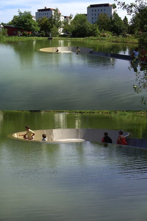 Sunken Platform in a Lake in Vöcklabruck, Austria where visitors are able to sit in the middle of a pond without getting wet. The landscape includes a path leading down to a hollowed out circular area where people can take a seat amongst nature. It's a surreal journey along the gradual ramp to the observational platform as the water level gains height either side. Once in the resting area, depending on perspective, visitors seem like they're wading in the lake without a drop of water on them. House On Water, Water Platform, Water Architecture, Floating Architecture, A Drop Of Water, Outdoor Space Design, Public Space Design, Drop Of Water, Artificial Lake