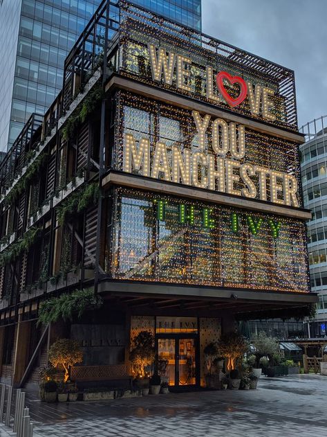 Modern building at twilight with illuminated text We Love You Manchester and The Ivy Manchester London, Manchester Buildings, England Manchester, Manchester In Winter, Manchester City Centre Aesthetic, Uk Manchester, Manchester Instagram Story, Manchester Trip, Living In Manchester