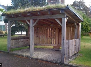 http://creativestarlearning.blogspot.com/     A shelter for parents waiting to pick-up children Allotment Structures, Garden Shelter Ideas, Community Seating, Log Shed, Field Shelters, Turf Roof, Garden Shelter, Bbq Shed, Shelter Ideas