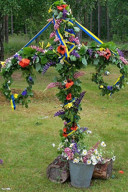 Midsummer - Midsummer  / AND May Day (May 1st)  the ribbons represent the flag -- this one is Swedish -- the 2 wreaths hang on the T shape pole -- w/vines & flowers wrapped around it all -- There's a ribbon winding around to music with Folk in National Costumes from their regions. Swedish Traditions, Swedish Girls, Scandinavian Countries, Swedish Style, May Days, Nordic Countries, How To Wrap Flowers, Hanging Wreath, Beltane