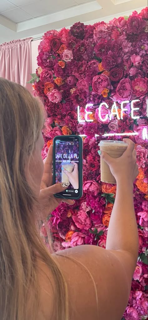 Girl holding coffee up to a gorgeous pink floral background at a local coffee shop in Malibu Cafe Interior Design Instagramable, Flower Coffee Shop Aesthetic, Coffee Shop Backdrop, Instagramable Coffee Shops, Flower And Cafe Shop, Floral Coffee Shop Aesthetic, Girly Coffee Shop Aesthetic, Pink Aesthetic Coffee Shop, Girly Coffee Bar