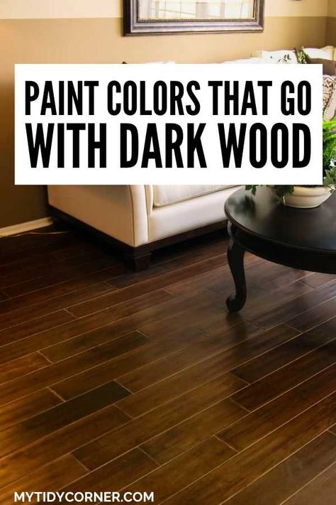 Love dark wood but unsure about paint colors? Discover the top paint colors that go with dark wood trim, floors, cabinets, furniture, paneling, etc. Here are the best paint colors that go well with dark wood. Enhance your decor with the best paint colors that pair with dark wood! Create a harmonious look with these paint colors that pair well with dark wood. Dark Wood Floor Hallway Ideas, Paint To Compliment Dark Wood, Living Room Inspiration With Dark Floors, What Color Paint Goes With Dark Wood Floors, Dark Hardwood Floors Decor, Wall Paint Colors With Dark Wood Floors, Paint Colors Dark Wood Floors, Wood Trim Colors, Paint That Compliments Dark Wood