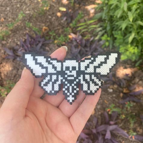 Skull moth made from mini perler beads! (can be made into keychain/necklace/earrings, DM on instagram @feastoncreations to request) Perler Bead Skull Patterns, Pentagram Perler Beads, Perler Bead Patterns Space, Enderman Perler Beads, Pearler Bead Halloween Patterns, Slipknot Perler Beads, Jellyfish Perler Beads, Icp Perler Bead Patterns, Wednesday Addams Perler Beads