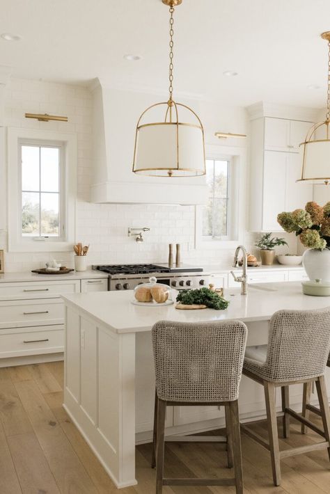 White Islands In Kitchen, Brass And White Kitchen Pendants, Brass Kitchen Island Pendants, Traditional White Kitchen Design, Pendants Over Peninsula Kitchens, White And Brass Pendant Lights Over Kitchen Island, White Kitchen Lights, White Kitchen Brass Fixtures, Kitchens With Polished Nickel Hardware