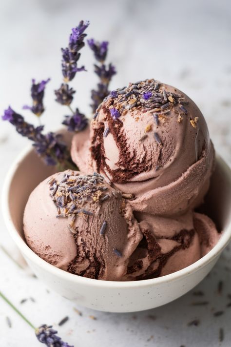 Lavender chocolate ice cream scoops in a bowl garnished with lavender flowers. Sour Ice Cream, Aesthetic Ice Cream Flavors, Vanilla Ice Cream Mix Ins, Ice Cream Combinations, Fun Ice Cream Ideas, Winter Ice Cream Flavors, Homemade Ice Cream Flavor Ideas, Interesting Ice Cream Flavors, Herbal Ice Cream