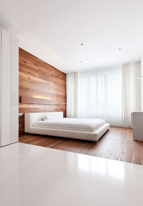 The sleeping area appears almost like one continuous, grand wooden headboard that drops from the ceiling and sweeps under the bed and across... Walnut Bedroom, Minimalist Dekor, Minimalist Bedroom Decor, White Apartment, Interior Design Minimalist, Minimal Bedroom, Minimalist Bedroom Design, Interior Minimalista, Design Hotel