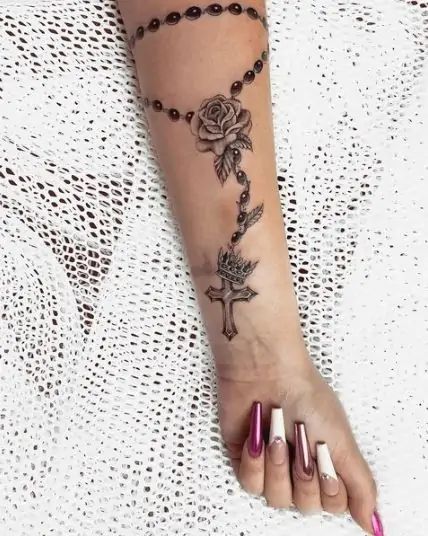 70 Cross Tattoos For Women That Are Easy To Bare Rosary Rose Tattoo, Rosary Tattoo Forearm Women, Rosary With Roses Tattoo, Crucifix Tattoo For Women, Rosary Tattoo Wrist Woman Crosses, Rosary Cross Tattoo, Tattoos For Women Cross, Rosary Tattoo For Women Arm, Rosary Tattoo Design