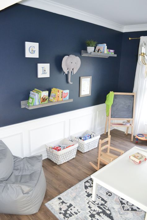 A renovated playroom featuring Goodnight Moon - a strong midnight blue paint color that's dark and alluring, like an infinite, moonlit sky. #paint #paintcolors #navy #bluepaint #playroom Blue Paint Colors For Bedroom Boys Behr, Navy Blue Chair Rail Bedroom, Navy Blue Playroom Ideas, Navy Playroom Ideas, Navy Blue Nursery Paint Color, Goodnight Moon Paint Color, Blue Boy Bedroom Ideas, Dark Blue Playroom, Midnight Blue Nursery