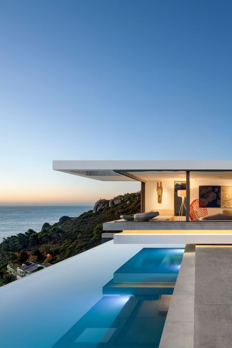 An infinity swimming pool and luxury villa overlooks the ocean at sunset. Villa With Infinity Pool, Cape Town Mansions, Cape Town Villa, Cape Town Beach House, Luxury Spanish Villa, Villa On The Beach, Town House Aesthetic, Dream Beach Houses Luxury, Cape Town Houses