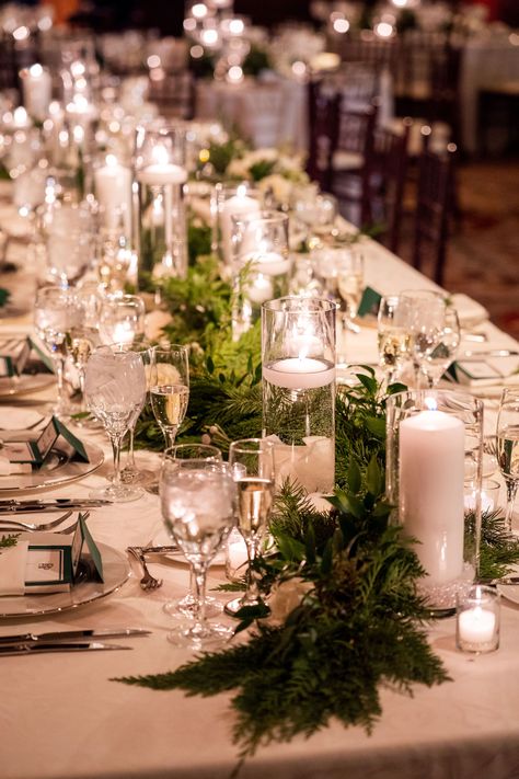 This long table was adorned with winter greenery and a lot of candles to warm up the space. Candle Greenery Centerpiece, Greenery Tablescape, Winter Wedding Candles, Mountain Wedding Decor, Head Table Wedding Decorations, Winter Mountain Wedding, Evergreen Wedding, Wedding Table Themes, Winter Wedding Table