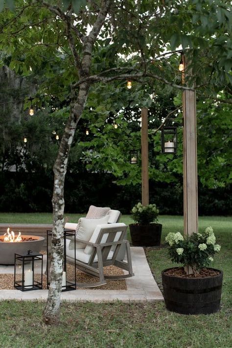 Easy and Cheap DIY Outdoor Lighting Idea. Patio makeover with backyard string lights and DIY planter posts to hang them. Outdoor Patio Ideas Small Spaces With Fire Pit, Outdoor Sitting Area Under Tree, Stepping Stones Fire Pit, Canopy Over Patio, Backyard Patio And Garden, Farmhouse Firepits Backyard Ideas, Pavered Fire Pit Area, Townhouse Backyard Garden, Magnolia Front Porch