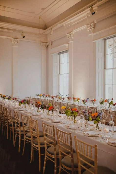 Wedding banquet tables have something romantic about them. Jess and Ally's bright flowered wedding tablescape was nothing less than stunning. Colorful Indoor Wedding Reception, Colorful Ballroom Wedding, Spring Banquet Table Decorations, Buffet Wedding Table Setting, Banquet Table Wedding, Bud Vases For Wedding, Long Wedding Table Decorations, Wedding Buffet Table Decor, Banquet Table Decor