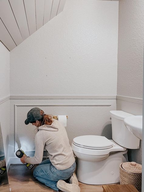 woman installing picture frame molding in a powder room Half Bath Molding, Wall Paneling Powder Room, Wall Trim Moulding Bathroom, Box Molding Small Bathroom, Paneling In Powder Room, Powder Room With Molding, Easy Powder Room Updates, Molding In Powder Room, Small Bathroom Molding Ideas