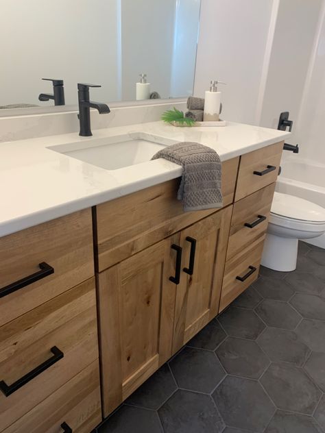 Wood Bathroom Vanity With Black Hardware, Light Oak Floors Grey Cabinets, Wood Vanity White Countertop, Natural Wood Bathroom Cabinets Modern, Black White Natural Wood Bathroom, White Oak Cabinet Bathroom, Oak Vanity Black Hardware, Dark Tile Floor Bathroom Wood Vanity, Re Stain Bathroom Vanity