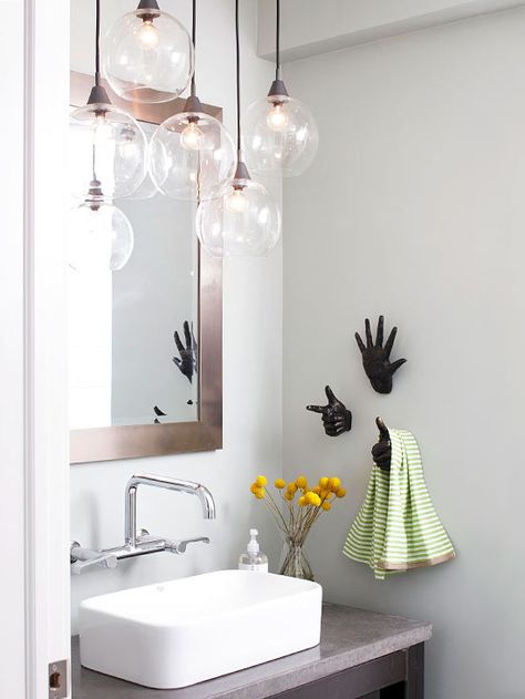 The organic shape of this blown-glass light fixture works well in the contemporary-style bathroom. Modern spaces can feel cold and be full of hard edges, but the round globes on the light fixture and the hand-shape towel hooks in this bathroom add a touch of playfulness. Best Bathroom Lighting, Bathroom Chandelier, Blown Glass Lighting, Remodel Diy, Glass Light Fixture, Small Bathroom Vanities, Bathroom Pendant, Bathroom Pendant Lighting, Decor Baie