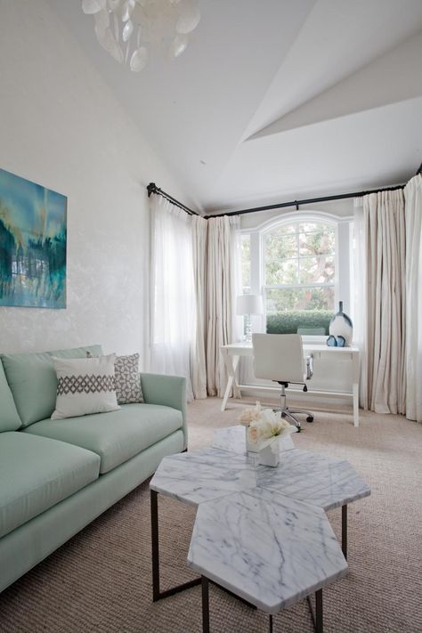 Light and refreshing, this sitting room just off the master bedroom features blue and green accents that reflect the ocean hues. A lovely mint green sofa and hexagonal coffee table with a marble top offers a place to sit and relax. In the opposite corner of the room, an X-based desk and neutral rolling chair form a bright and airy office nook. Mint Living Rooms, Green Furniture Living Room, Green Sofa Living, Green Couch Living Room, Mint Bedroom, Lindye Galloway, Personal Retreat, Office Nook, Modern Couch