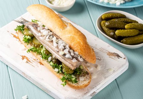 Broodje Haring | Traditional Sandwich From Netherlands | TasteAtlas Seafood Sandwich, Herring Recipes, Seafood Sandwiches, Pickled Cucumber, Snack Bites, Street Foods, Dutch Recipes, Pickling Cucumbers, Diced Onions