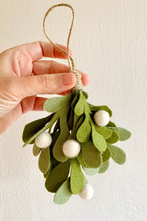 Individual Handmade Felt Christmas Mistletoe Ornament This beautiful handmade Christmas decoration can be hung on your Christmas tree or anywhere around the house to bring a bit of festive cheer! Each ornament is handmade from moss and sage coloured wool felt, decorated with individual white felt balls. Each ornament measures approx 20cm in height including a traditional brown twine hanging loop of approx 7cms. Please be advised that this is a decorative ornament and not a toy and should be kept Winter Handmade Decorations, Christmas Ornaments Felt Diy, Hanging Felt Decorations, Felt Winter Crafts, Christmas Felt Decorations Hand Sewn, Felt Christmas Tree Craft, White Felt Christmas Decorations, Sew Christmas Decor, Cute Christmas Wreaths