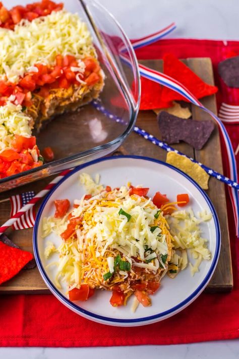 Looking for patriotic red, white, and blue appetizers for your patriotic party food? This super easy American flag taco dip is no-bake and quick to make! Just layer the taco dip ingredients, and top with tomatoes, shredded cheese, and crushed up blue corn tortilla chips... seriously so easy and SO good! Blue Appetizers, July 4th Appetizers, Patriotic Party Food, Blue Tortilla Chips, Cheese Stars, Blue Corn Chips, Blue Corn Tortillas, Cheese Tacos, Patriotic Food