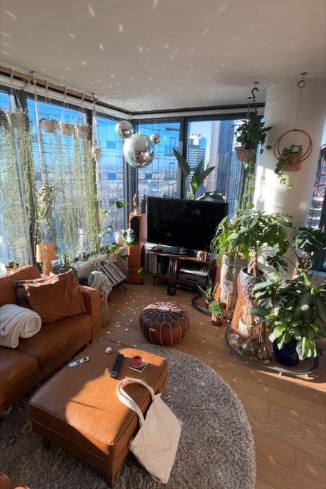 Filled with plants, flooded with natural light, bohemian interior design, boho, house plants, disco ball, hanging plants, nyc, manhattan skyline, crystals, Monstera, birds of paradise, succulents, Monstera, Highrise building, luxury apartment inspo, Manhattan Views, Apartment with city views Crochet Curly Hair, Nashville Apartment, Boho Apartment, Nyc Penthouse, Boho Apartments, Vintage Apartment, Cosy Apartment, Apartment Plants, Cosy Room