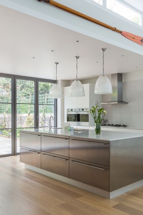 This enormous stainless steel island is hard not to notice thanks to its sheer size! But it’s also a beautiful and practical piece of kitchen furniture that not only ties the entire scheme together but provides ample storage space and a spacious social/eating area #bespokekitchen #luxuryinteriors #modernkitchens https://www.solakitchens.com/fresh-new-start/ Stainless Island Kitchen, Stainless Steel Island Kitchen, Steel Island Kitchen, Kitchen Bulkhead, Dapur Kotor, Bayswater London, Stainless Steel Kitchen Island, Stainless Steel Island, Tall Kitchen Cabinets