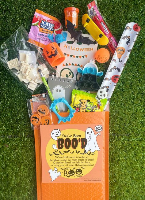 You've been Boo'd Gift Bags come in a 6x10 bubble mailer filled with a mystery variety of fidget toys, candy, Halloween classic trinkets, and a "You've Been Boo'd" card that you can leave a personal message. This is the perfect trick or treat gift to send or even surprise yourself.  FAQ  What does "You've Been Boo'd" mean?  🎃 A Halloween boo is a small gift or treat left anonymously by a friend, family, or neighbor!  Have a little ghoul or goblin you are wanting to surprise this Halloween?!  🎃 Send them a Boo Bag! We can keep it a secret between the two of us or you can reveal who you are with a personalized note.  What's in the Boo Bag? 👀 🎃 A Boo Bag arrives in a 6 x 10 bubble mailer that contains a card informing the receiver that "THEY'VE BEEN BOO'D" alongside about 12 - 15 mystery Boo Bags Halloween, Boo Bags, Youve Been Bood, Mini Boo, Boo Baskets, Boo Boo Bags, Halloween Mystery, Halloween Goodie Bags, Youve Been