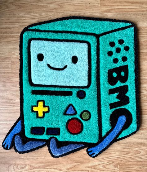 "Who wants to play video games?! This Adventure Time BMO rug is tufted by hand. It would be a mathematical addition to any space either as a floor rug or a wall hanging! All rugs feature double reenforced edges and thick felt backing for added durability.  This rug is 24x21\" *Please allow 2-6weeks processing time as each rug is made to order. Processing time is based on stock and workload." Artsy Rug, Video Game Rug, Gaming Rugs, Adventure Time Rug, Tuft Rugs, Rug Tufting Ideas Easy, Tuft Rug Design Ideas, Tufting Ideas Beginner, Tufted Rug Design Ideas