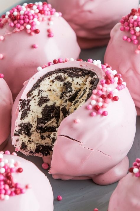 Close-up of an Oreo truffle ball cut in half, highlighting the creamy, Oreo-filled center and pink candy shell topped with pink, white, and red sprinkles. Perfect for romantic or festive occasions. Keywords: Oreo truffle close-up, pink sprinkle toppings, festive dessert ideas, Oreo and cream cheese filling, eye-catching desserts. Pink Treats For Birthday Party, Pink Oreo Balls, Dessert For Baby Shower Girl, Pink Baby Shower Dessert Table, Baby Shower Treats Girl, Pink Treats For Party, Oreos Balls, Cake Truffle Balls, Oreo Cream Cheese Balls