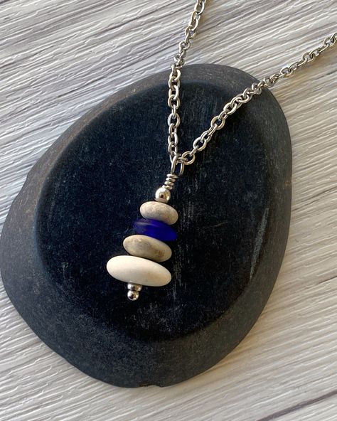 Cairns have long been used to mark trails and paths so that we don’t lose our way in the wilderness. Take a little bit of the trail with you wherever you go with this dainty cairn necklace. Three hand drilled pebbles and a heishi glass bead are hung on small stainless steel chain. Comfortable and easy to wear. Stainless steel chain and findings won’t tarnish, and won’t irritate sensitive skin. -Stainless steel findings and chain -Hand drilled natural beach pebbles and an indigo glass heishi bead Cairn Necklace, Beach Pebbles, Heishi Necklace, Sea Glass Necklace, Blue Flats, Heishi Beads, Cairns, The Wilderness, The Trail