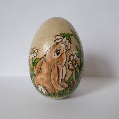 Two cute rabbits nose around white diasy flowers and green leaves on this wooden egg. Design is wood burned on a solid wooden egg. Egg is approx. 2 1/2 inches tall. The shading is an effect of the wood burning with coloring added using special pencils. Egg is sealed with a clear acrylic sealer. This Easter Drawings, Creative Easter Eggs, Easter Paintings, Easter Wood Crafts, Easter Egg Art, Carved Eggs, Egg Design, Wood Eggs, Crafts Easter